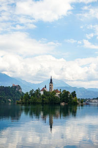 View of building by lake against sky