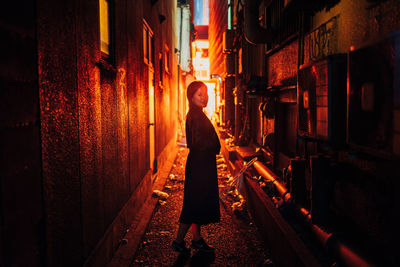 Woman walking on illuminated building at night