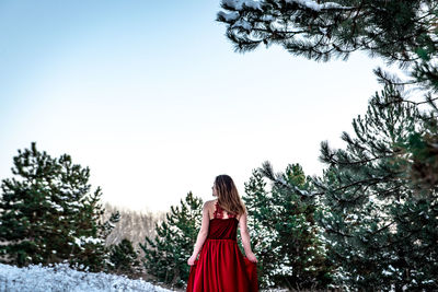 Woman standing by plants against sky