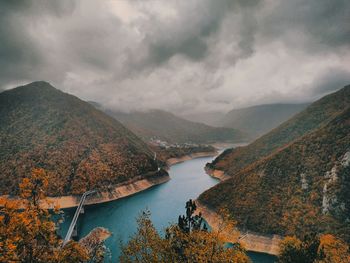 Scenic view of lake by mountains against sky