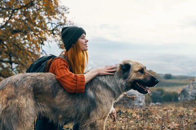 Side view of woman with dog looking away