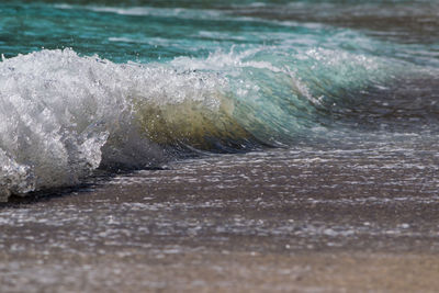 Close-up of sea waves splashing on beach