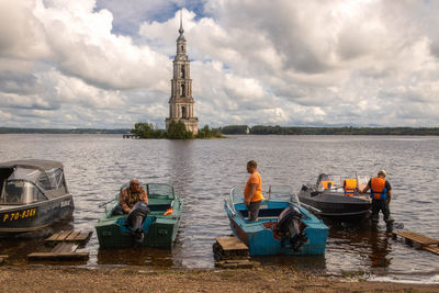 People in boat against sky