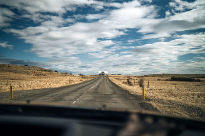 Road against sky seen through car windshield