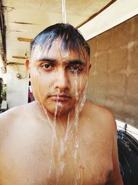 Close-up portrait of shirtless man taking bath outdoors