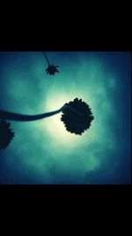 Silhouette of airplane flying against cloudy sky