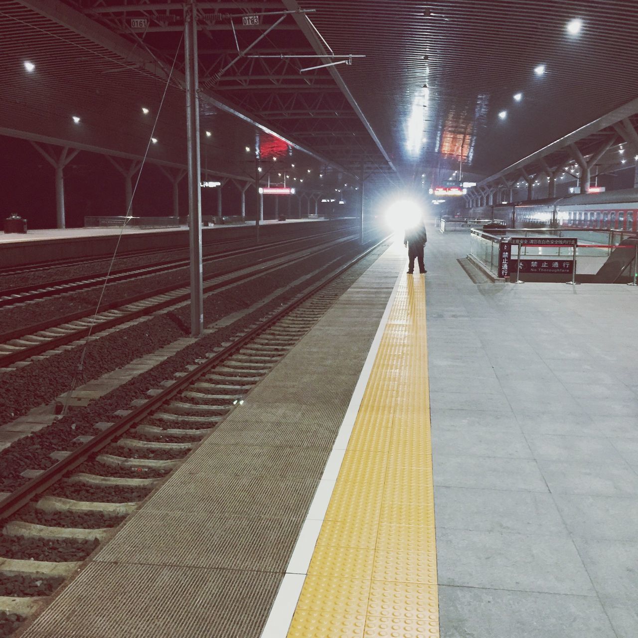 the way forward, illuminated, railroad track, lifestyles, transportation, walking, men, railroad station, railroad station platform, built structure, architecture, diminishing perspective, full length, rear view, person, lighting equipment, leisure activity, vanishing point