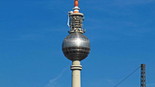 Low angle view of communications tower against blue sky