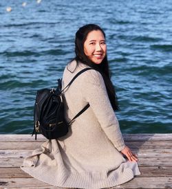 Portrait of smiling young woman standing in lake