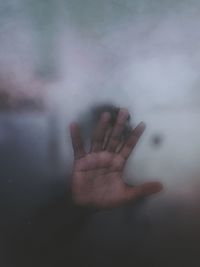 Close-up of human hand amidst smoke