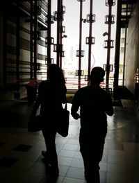 Silhouette man in city at sunset