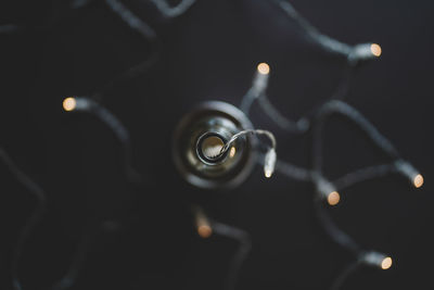 Close-up of illuminated lighting equipment against black background