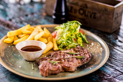 Close-up of steak and fries served on plate