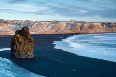 Rock formation in sea against sky