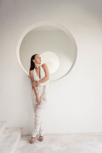 Young girl with long hair in full growth in white clothes on a white background