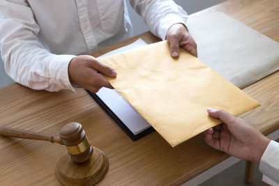 High angle view of man holding hands on table