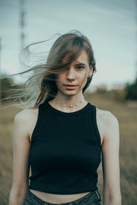 Young woman standing against sky