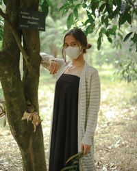 Woman standing by a tree