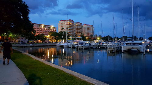 Sailboats moored on canal in city at night