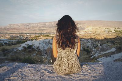 Rear view of woman walking on snow covered land