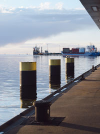 Close-up of commercial dock by sea against sky