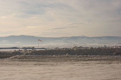 Scenic view of frosty land against sky