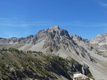 Scenic view of mountains against blue sky