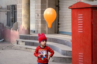 Portrait of cute boy with red balloons