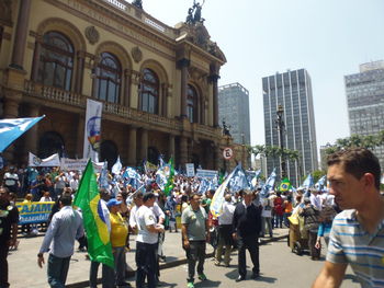 Crowd in city against sky