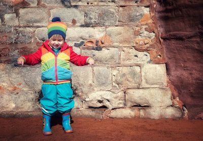 Portrait of boy standing against wall