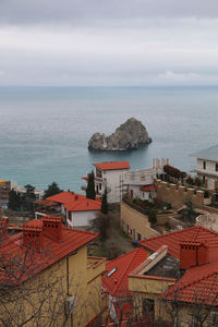 High angle view of townscape by sea against sky