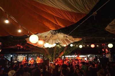 Low angle view of illuminated lanterns hanging against sky at night