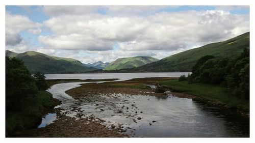 Scenic view of lake and mountains against sky