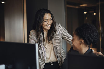 Happy female business colleagues communicating with each other