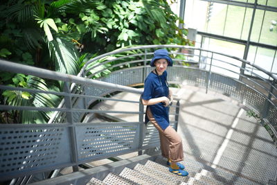 Portrait of boy on railing against trees