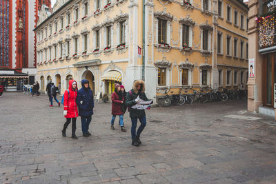 People on street amidst buildings in city