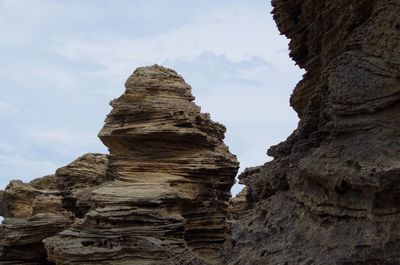 Low angle view of rock formation against sky