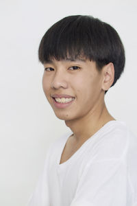 Portrait of smiling teenage girl against white background