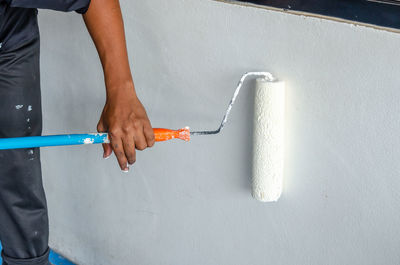 Midsection of woman working on wall