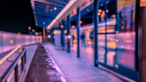 Illuminated railroad station platform seen through window at night