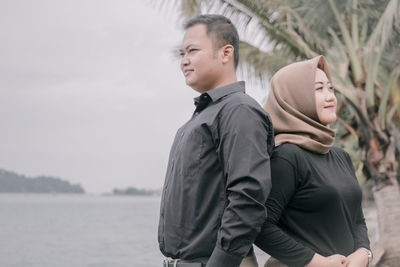 Side view of a young couple looking at sea