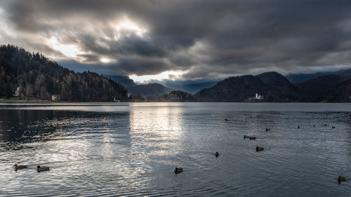 Scenic view of lake by mountains against sky