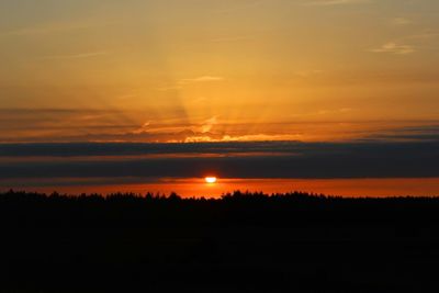 Scenic view of silhouette landscape against orange sky