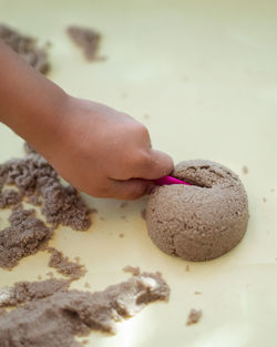 Child's hand playing with kinetic sand in preschool. develop fine motor concept. creativity game.
