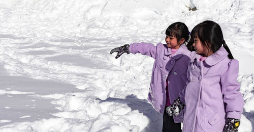 Woman standing on snow covered ice