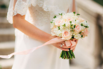 Midsection of woman holding flower bouquet