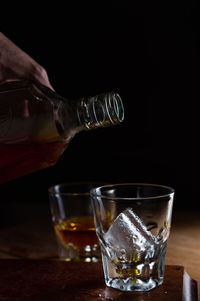 Close-up of wine glass on table against black background