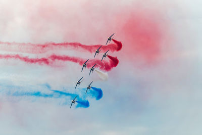 Close-up of pink airplane flying against sky