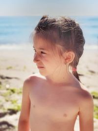 Midsection of shirtless girl at beach