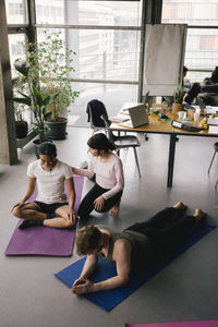 High angle view of colleagues exercising at workplace